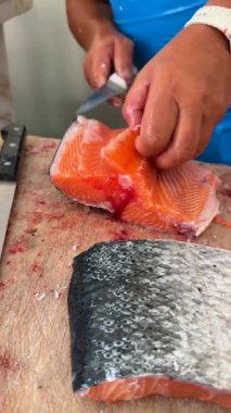 Son derece yetenekli ve titiz bir şekilde hazırlanmış taze somon balığı filetosunu izleyin.