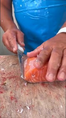 Son derece yetenekli bir el ustaca fileto balığı taze somon balığı, hem hassasiyet hem de deniz ürünleri hazırlama kalitesinde sergileniyor.