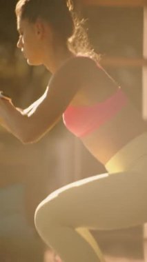 Bir kadın açık hava ortamında direnç çubuklarını kullanarak şınav çeker. Güç ve kararlılık gösterir..