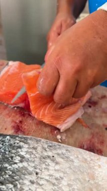 Becerikli ellerle usta somon filetosu, deniz ürünleri hazırlamada ustalık ve ustalık gösterisi..