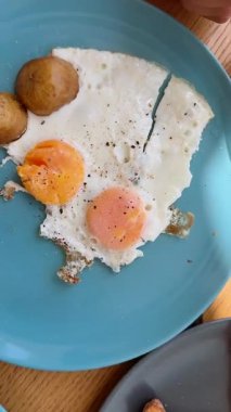 Yumurta, tost ve ahşap bir masada çeşitli renklerde yayılan lezzetli ve ağız sulandırıcı bir kahvaltı.