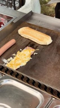 Lezzetli, ağız sulandıran bir omlet ve ızgarada ustalıkla pişirilmiş sosisli sandviçi izleyin.