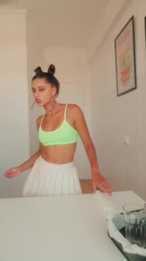 Neşeli bir kadın, canlı mutfağında yemek pişirmekten ve yemek tarifleri denemekten hoşlanır, şık kıyafetler giyer.