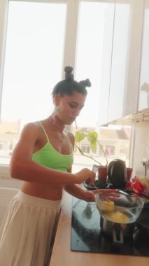 Kendini adamış bir birey, güneşli bir mutfakta ustalıkla yemek pişirme tutkusunu sergiliyor.