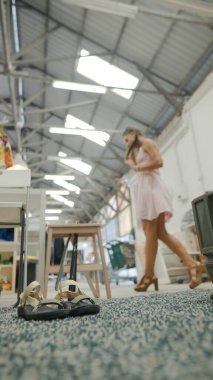 Pembe elbiseli şık bir kadın modern endüstriyel ortamda yürüyor, moda ve zarafeti gözler önüne seriyor..