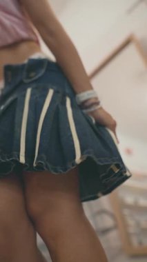 Moda bir kot etek şık aksesuarlarla güzelce eşleştirilir, hepsi canlı bir ortamda sergilenir.