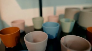 Modern tasarım eğilimlerini güzel bir şekilde gözler önüne seren renkli seramik bardakların estetik açıdan hoş bir düzeni.