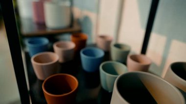 Çok canlı bir seramik kap koleksiyonu çeşitli renkler ve stillerde, zarif bir şekilde sergilenmiş.