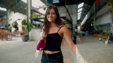 Tarz sahibi genç bir kadın renkli ve hayat dolu canlı bir şehir ortamında benzersiz modasını sergiliyor.