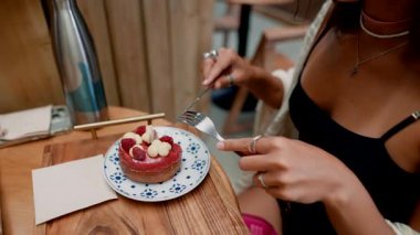 Moda bir kafede taze meyveyle süslenmiş lezzetli bir dilim pastanın tadını çıkarıyorum.