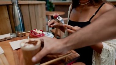 Bir kadın sıcak bir kafede kahve ve kekten zevk alır. Lezzetli bir tatlıdan zevk alır.