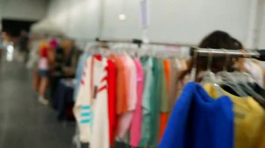 Çevrede renkli kıyafetler ve şık müşterilerle dolu canlı ve canlı bir moda pazarı keşfetmek.