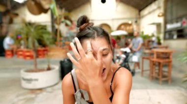 Genç bir kadın neşeli ve neşeli bir kafede, arkadaşlarıyla neşeli anları yakalıyor ve mutlu bir şekilde gülümsüyor.