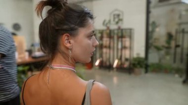 Zarif at kuyruklu şık bir kadın modern bir iç mekanda canlı yemyeşil ortamda zarif bir şekilde duruyor.