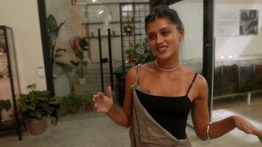 Kendine güvenen bir kadın modeller çağdaş giysileri bitkilerle dolu bir alanda, zarafeti doğayla harmanlıyor..