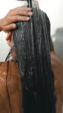 Bir insanı duşta gösteren büyüleyici bir an. Islak saçlarla ferahlatıcı bir deneyimin tadını çıkarıyor..