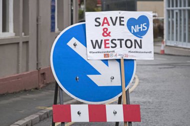 5 Şubat 2019 'da İngiltere' nin Weston-Super-Mare kentindeki Weston General Hospital 'da sunulan hizmetlerin azaltılmasını protesto eden göstericiler tarafından bir yol tabelasına yapıştırılan bir pankart.