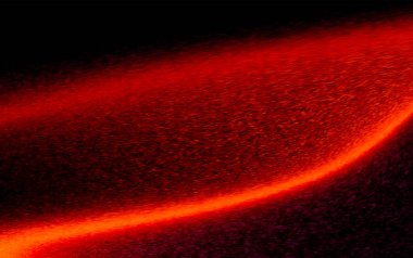 Kırmızı ve turuncu dinamik kıvrımlı ateşli soyut bir görüntü koyu bir arkaplana karşı, ısı ve hareketi işaret ediyor..