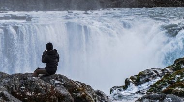 Selfoss 'a bakan bir turist vadinin kenarına atlıyor.