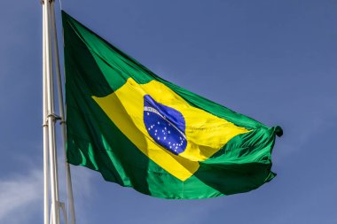 Arka planda mavi bir gökyüzü olan Brezilya bayrağını kapat.