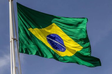 Arka planda mavi bir gökyüzü olan Brezilya bayrağını kapat.
