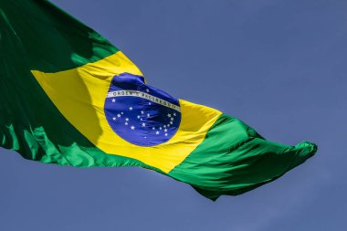 Arka planda mavi bir gökyüzü olan Brezilya bayrağını kapat.