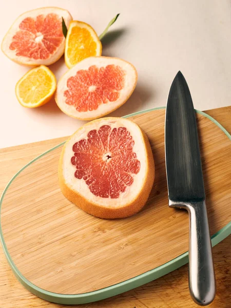 portakal ve greyfurt ağaçta bıçakla kesilmiş.