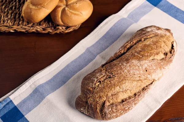 Ahşap masanın üzerinde un bulunan el yapımı ekmek.