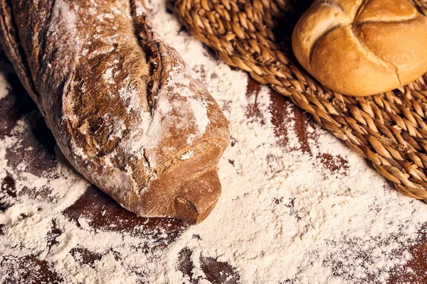 Ahşap masanın üzerinde un bulunan el yapımı ekmek.