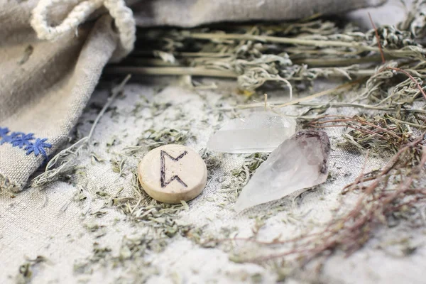 Scandinavian wooden rune Peor , PERTHRO on a rough linen cloth with amethyst crystalline, rock crystal and dried wormwood.