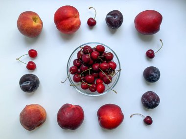 Şeftali, nektarin, erik ve kiraz beyaz arka planda. Yaz ferahlatıcı yemekler. Sağlıklı yiyecekler, vejetaryenlik, vitaminler.