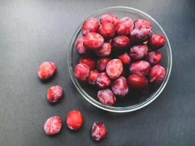 Siyah zemin üzerinde cam plaka olan taze erikler. Düzgün beslenme, vejetaryenlik, sağlık yardımları, vitaminler, diyet.