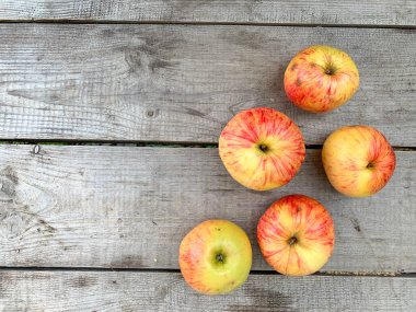 Yukarıdan çekilmiş tahta bir masa fotoğrafında taze elmalar. Hasat doğru yiyecekleri, vitaminleri yiyor. Masaüstünüzde ekran koruyucu