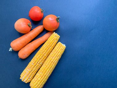 Siyah arka planda mısır koçanı, havuç, domates. Sağlıklı yemek. Vejetaryenlik. Ağız sulandırıcı atıştırmalıklar. Mısır gevreği, fasulye. Sebze. Yukarıdan fotoğraf..