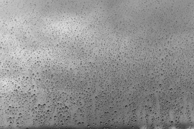 Arkaplanda yağmur damlaları olan gri cam