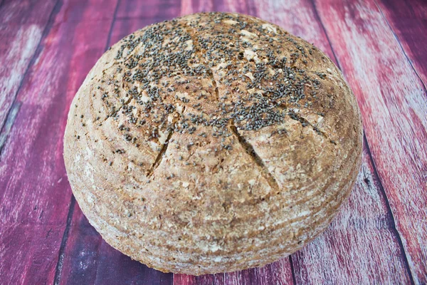 Ahşap bir zeminde chia tohumlu toptan ekmek.