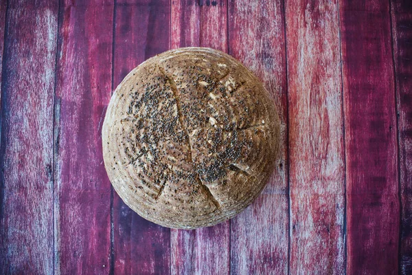 Ahşap bir zeminde chia tohumlu toptan ekmek.