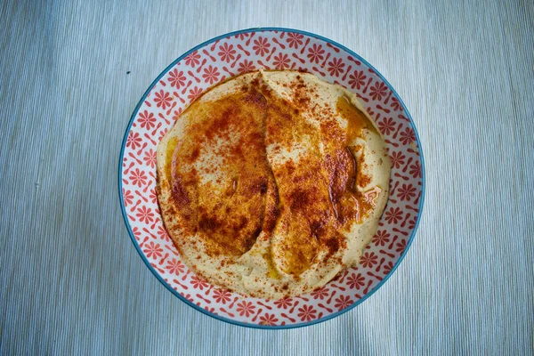 Kırmızı biberli ev yapımı nohut, beyaz ve kırmızı kâsede servis edilir.