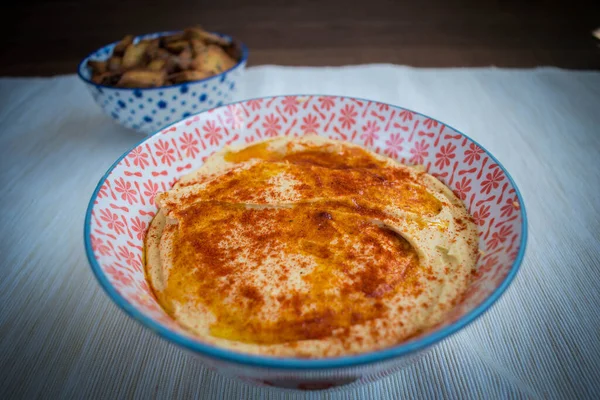Kırmızı biberli ev yapımı nohut humusu ve klozete daldırmak için çıtır ekmekler.