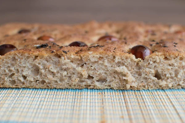 Foreground homemade bread Focaccia with cherry tomatoes and olive oil