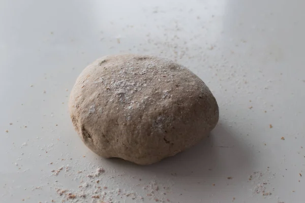 Üzerinde un ve beyaz arkaplan olan çiğ ekmek hamuru topu