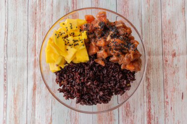 Çiğ organik ton balığı kasesi, yanında pilav ve sebzeyle masaya yakın çekim. Yukarıdan yatay görünüm