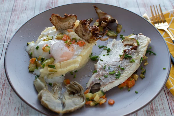 Sebzeli, yumurtalı ve enginarlı ızgara balık yakın plan..