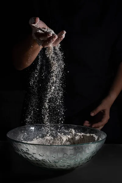 Fırıncı kadın elleri tek eliyle un çekiyor.