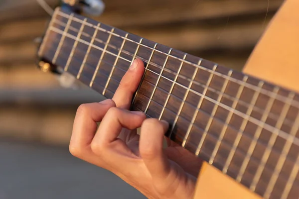 Yakın plan kadın elleri gitar çalıyor.