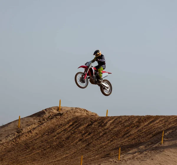 Biker jumping with his motorcycle doing stunt in a motocross racing