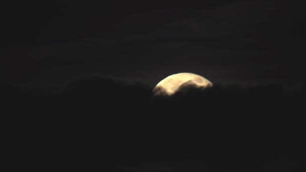 Pleine lune brillante voilée derrière des nuages sombres 