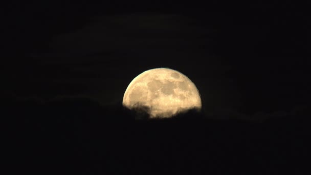 La pleine super lune se lève à travers les nuages sombres — Video