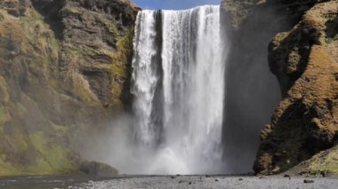 Skogafoss İzlanda şelalesi. Yakın çekim yavaş çekim kuşları güneşli günde uçuyor.