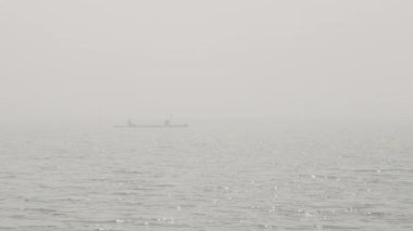 Okyanus kayığı yoğun düşük görüş mesafesinde Güneş dalgalar üzerinde parıldıyor